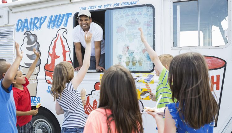 Group of children waving at man in ice cream truck
